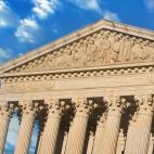The front of the U.S. Supreme Court with an American flag flying